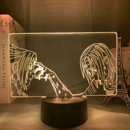 <img src="Illuminated LED lamp with an engraved acrylic panel featuring two anime characters facing each other, one touching the other's forehead. The lamp base emits a red glow,with Itachi and Sasuke illuminating the characters' outlines and creating a striking visual effect.">